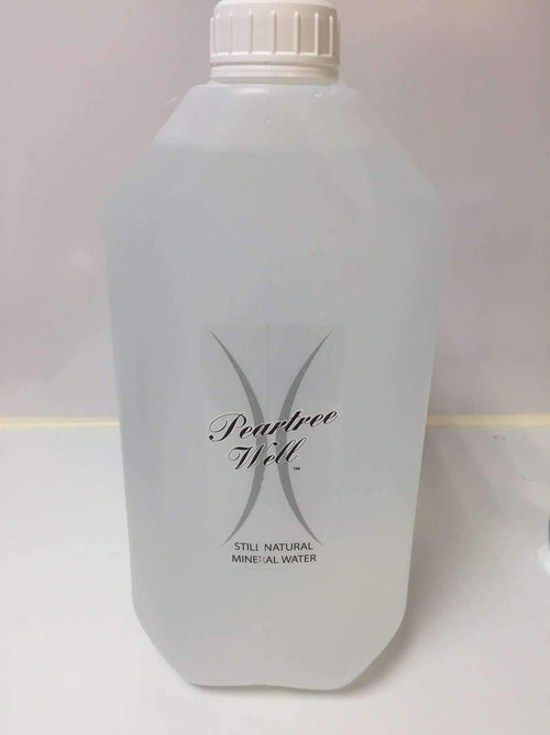 Front of a translucent container labelled Peartree Well Still Natural Mineral Water, with a white cap