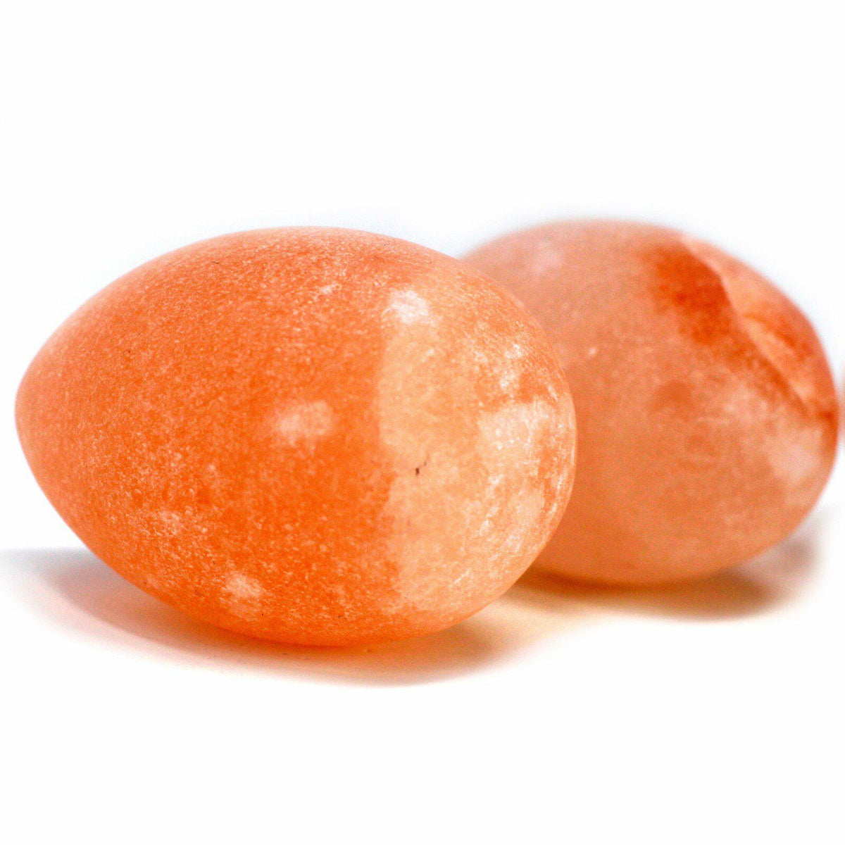 Pair of peach-pink egg-shaped salt deodorants, one in front of the other